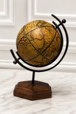 An antique-style decorative world globe featuring a vintage-finish parchment map on a black metal frame, supported by a dark hexagonal wooden base on a light stone tabletop