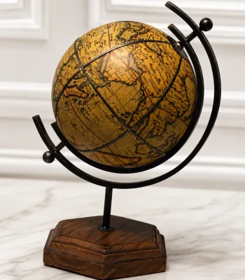 An antique-style decorative world globe featuring a vintage-finish parchment map on a black metal frame, supported by a dark hexagonal wooden base on a light stone tabletop