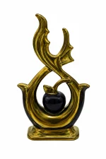 An elegant abstract ceramic sculpture featuring high-gloss gold metallic flame-like loops framing a central black apple with a leaf, standing on a round wood-grain accent pedestal table