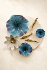 Modern 3D ceramic wall art featuring blue and white floral designs with metallic gold leaf accents mounted on a circular base.
