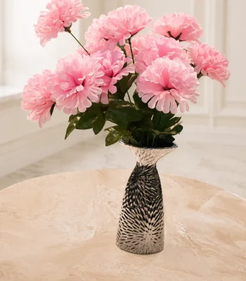 Textured silver vase filled with pink flowers on a marble table