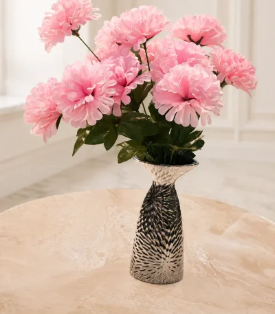 Elegant pink artificial flower bouquet arranged in a decorative black and silver ceramic vase on a marble table.