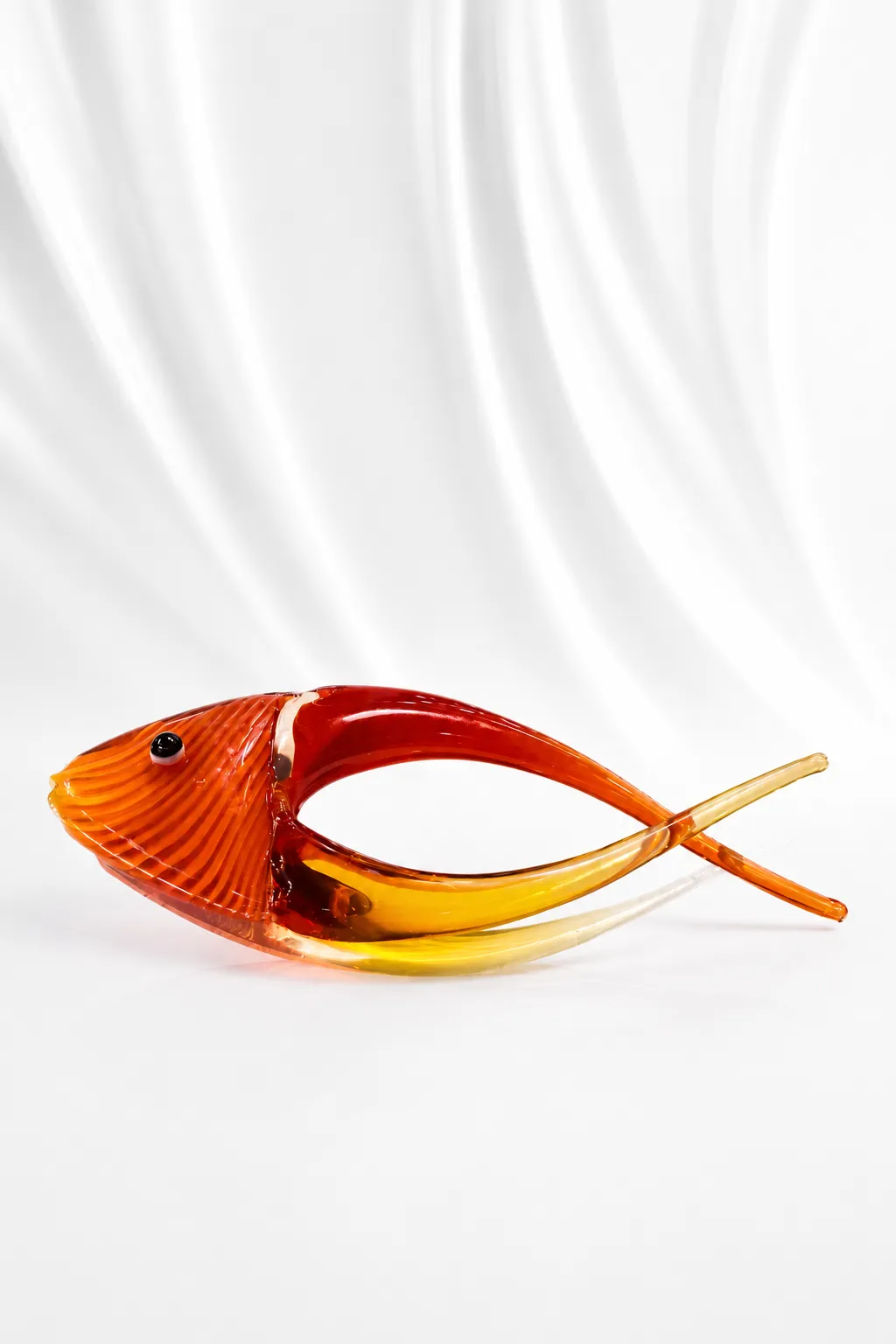 Handcrafted Amber Glass Fish Figurine | Modern Decorative Table Accent Handcrafted amber glass fish figurine with a translucent golden tail displayed on a marble table.