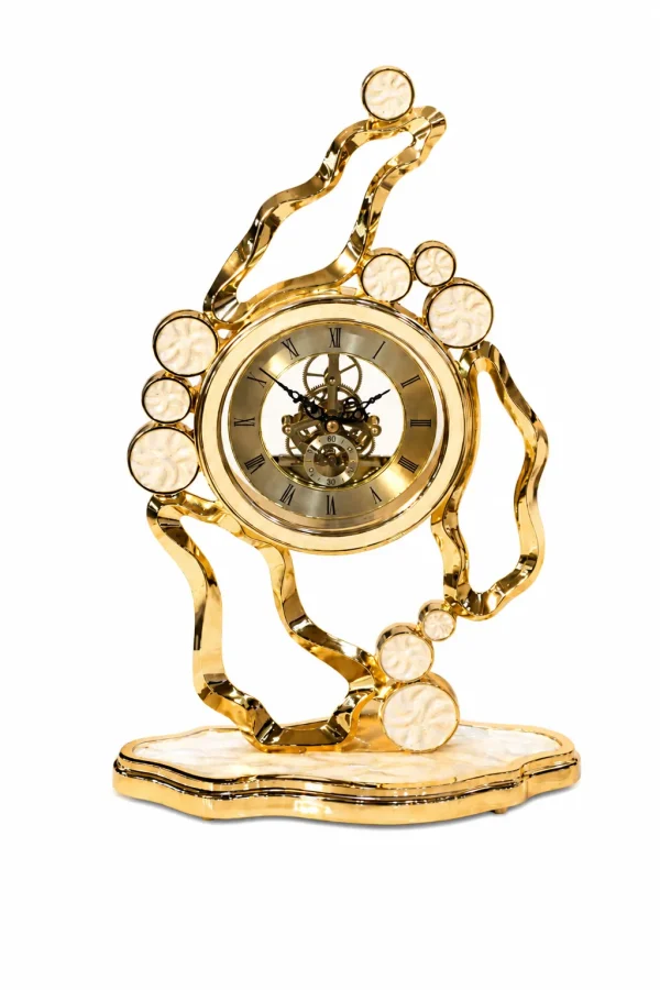 Luxury gold metal table clock with a decorative bird perched on a branch, featuring a skeleton dial, Roman numerals, and a crystal-studded bezel.