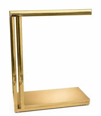 A modern minimalist C-shaped side table crafted entirely from polished gold metal with dual vertical pillars and a rectangular base, isolated against a white background.