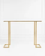 Modern gold console table with a minimalist white top and geometric metal frame legs, set against a clean white wall paneling backdrop.
