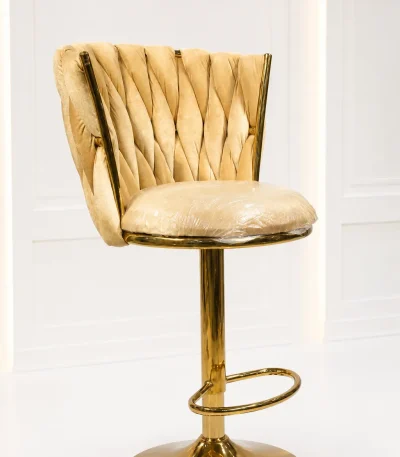 Luxury gold velvet bar stool from featuring a cream tufted woven velvet backrest and a polished metallic gold pedestal base.