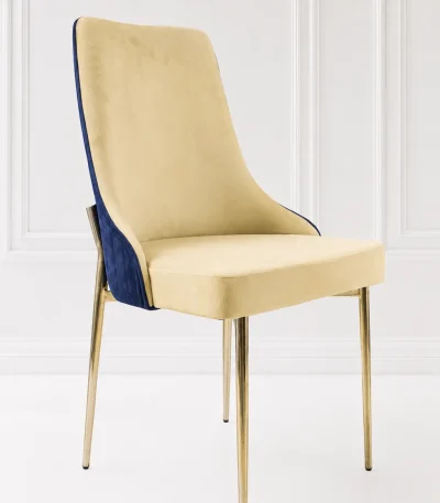 Modern velvet dining chair from featuring a dual-tone beige and navy blue upholstered seat supported by slim polished gold leg