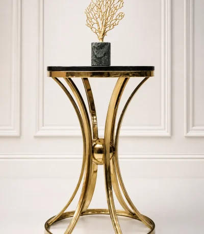 Luxury modern round side table featuring a polished black marble top and a decorative hourglass-shaped gold metal pedestal base, holding a gold coral sculpture.