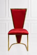 Luxury high-back dining chair featuring royal red velvet upholstery and a polished gold metallic trim frame against a white paneled wall background.