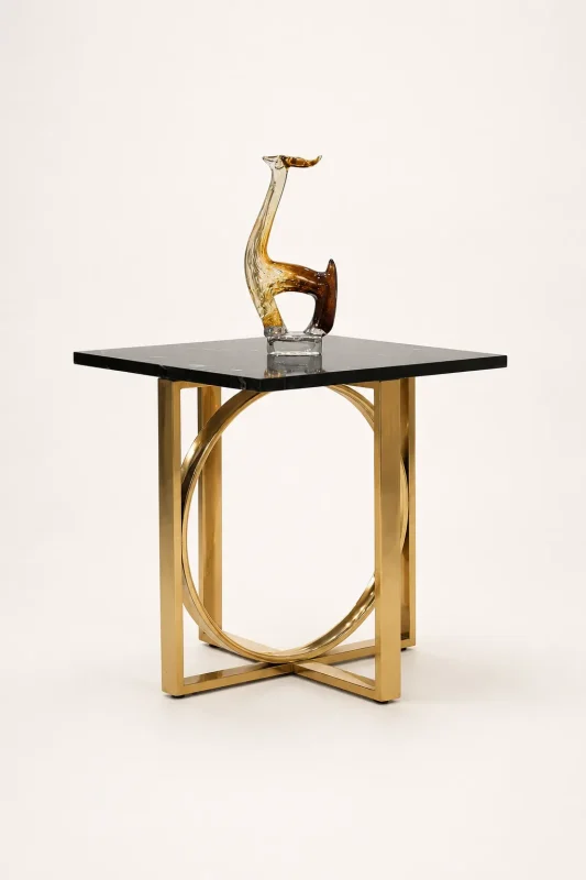 Contemporary square black accent table featuring a polished gold stainless steel geometric ring base frame with a decorative glass sculpture on top,