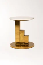 Modern gold side table with a sleek round white tabletop and a high-shine polished brass stepped pedestal base, isolated against a clean white background.