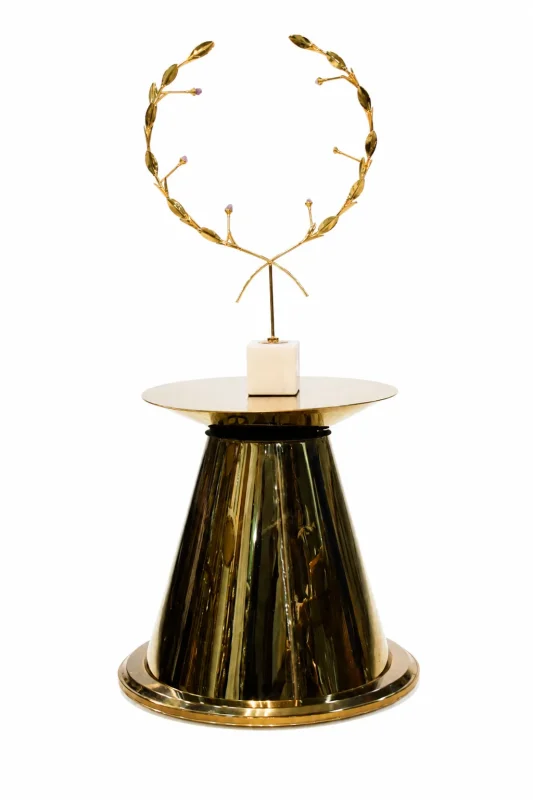 Round black marble side table with a polished dark stone top and a modern architectural multi-pillar gold metal base, isolated against a white background.