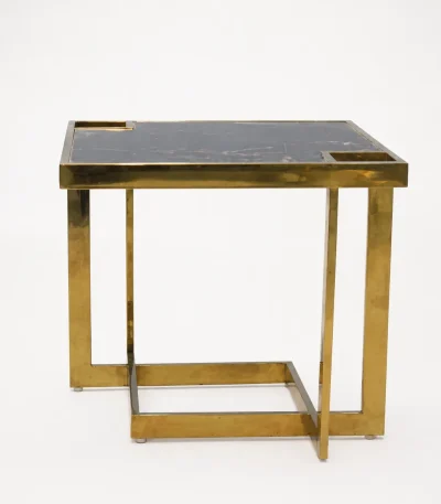 Square black marble side table featuring a thick polished gold metal frame and an interlocking open cubic base, isolated against a solid white background.