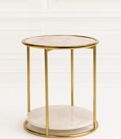 Modern round marble side table with gold frame displayed against a clean, white minimalist paneled wall backdrop in file