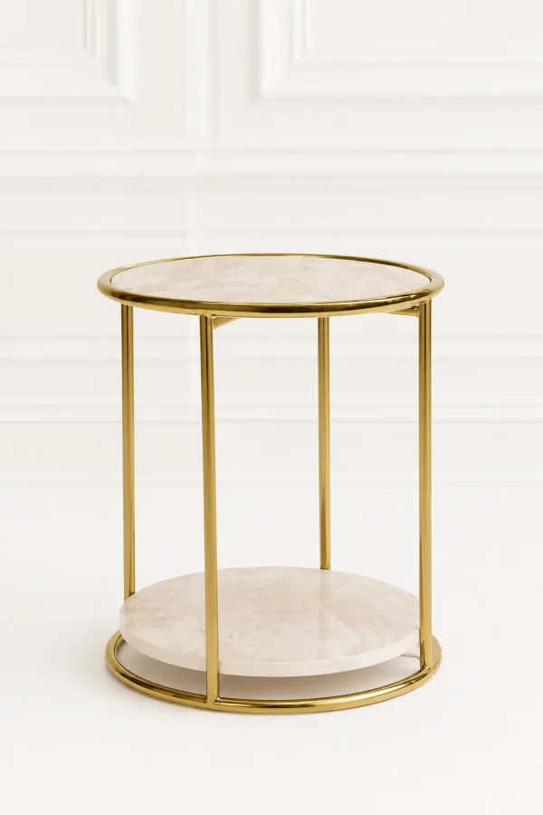 Modern round marble side table with gold frame displayed against a clean, white minimalist paneled wall backdrop in file