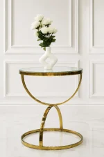 Luxury round glass top side table with gold crescent base featuring a white vase of roses