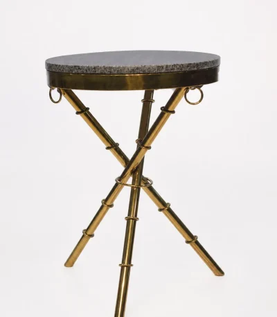 Luxury round granite top side table with gold tripod base featuring textured bamboo-style legs and ring accents