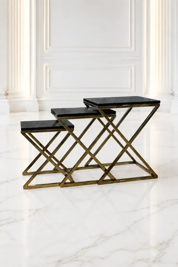 Set of three luxury rectangular black marble nesting tables with gold x base arranged in a tiered, staggered layout