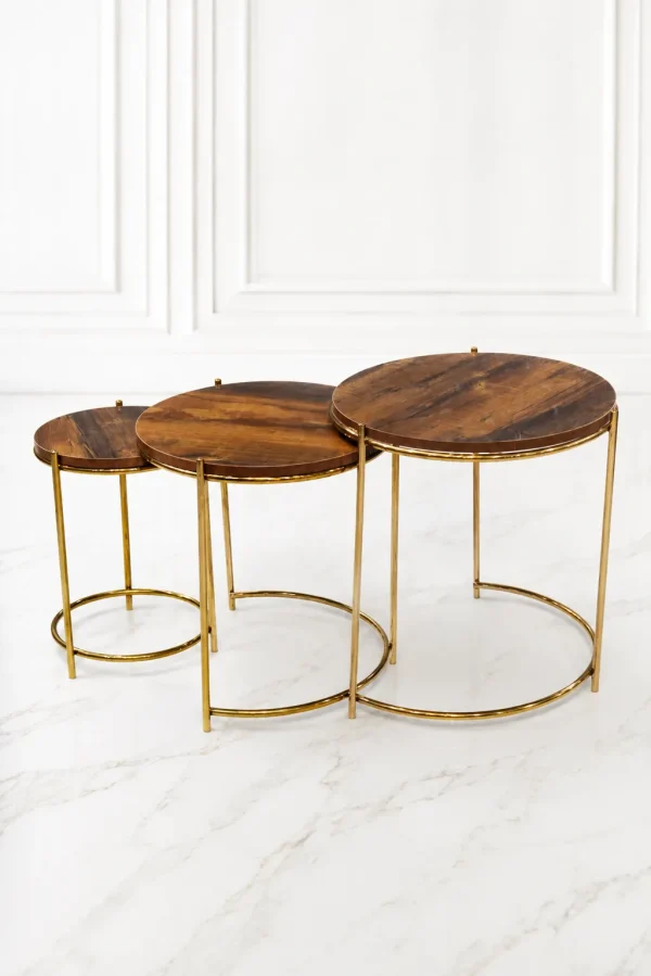 Set of three luxury round rustic wood nesting tables with gold frame arranged in a staggered, descending layout