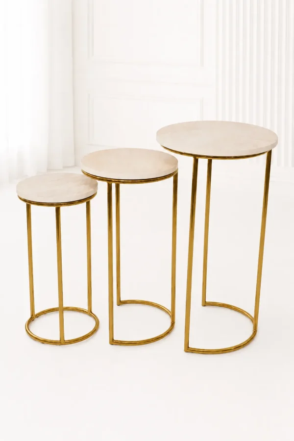 Set of three luxury round marble nesting tables with gold frame arranged in a staggered, descending layout,