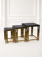 Set of three luxury square black marble nesting tables with gold reeded legs arranged in a tiered, descending layout