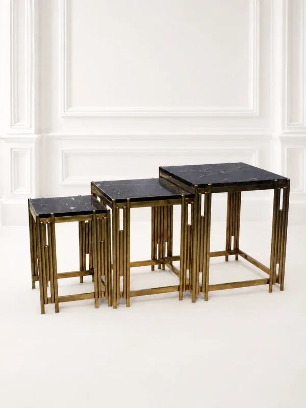 Set of three luxury square black marble nesting tables with gold reeded legs arranged in a tiered, descending layout