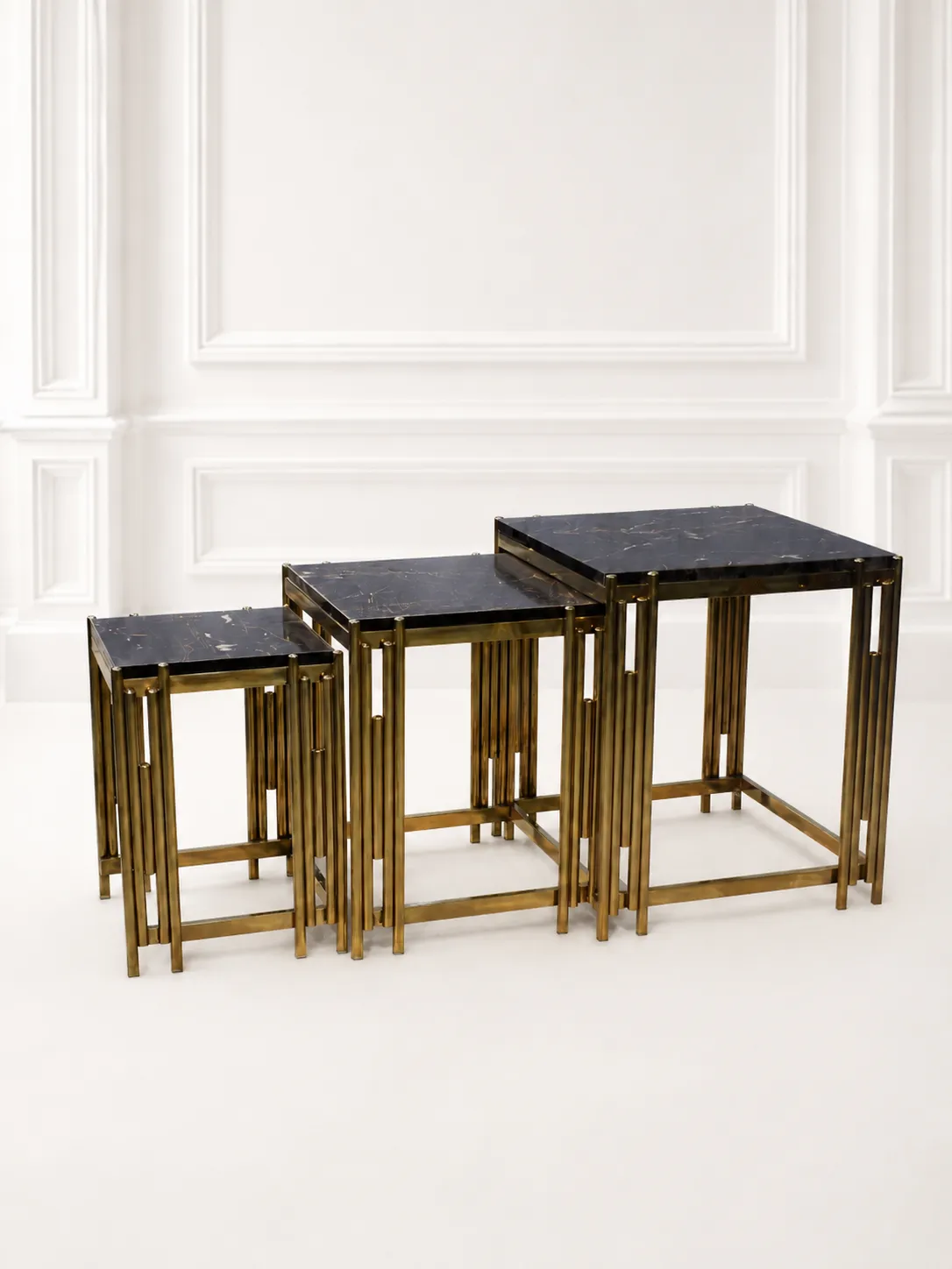 Luxury Square Black Marble Nesting Tables with Gold Reeded Legs – Modern Space-Saving End Tables Set of three luxury square black marble nesting tables with gold reeded legs arranged in a tiered, descending layout