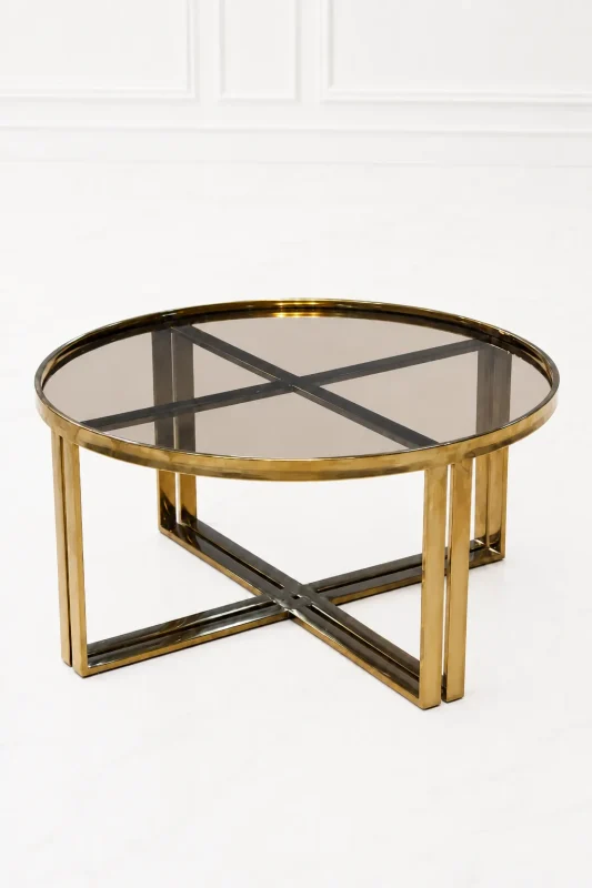 Luxury round smoked glass coffee table with gold x base featuring a translucent tinted glass top and dual-pillar metal legs