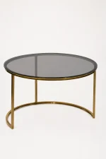 Luxury round smoked glass coffee table with gold crescent base featuring a dark tinted glass top and an open semi-circular metal foundation