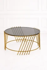 Luxury round smoked glass coffee table with gold slatted base featuring diagonal parallel metal rods extending past the glass top