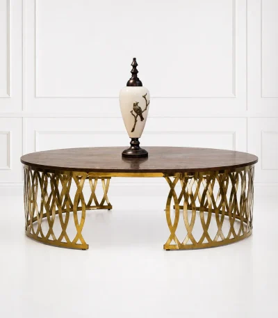 Luxury round wood coffee table with gold latticework base featuring a polished dark brown walnut grain top styled with a decorative white porcelain urn vase,