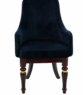 Luxury black velvet armchair featuring sloped armrests and sculpted dark wood legs with integrated polished gold ring accents, shown against a plain white background.