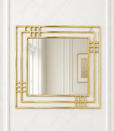 Square gold Art Deco wall mirror with a geometric multi-layered frame mounted on a minimalist white marble wall.