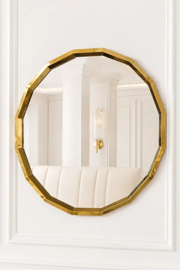 Luxury octagon gold wall mirror with a faceted geometric stainless steel frame mounted on a white paneled wall.