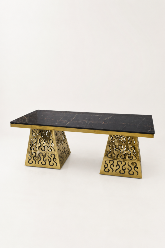 A luxury rectangular console table featuring a polished black marble top and two ornate, laser-cut gold-finished metal bases.