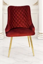 Luxury burgundy velvet dining chair with quilted back and gold metal legs.
