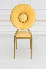 Modern gold stainless steel dining chair featuring a circular velvet backrest and elegant cream seat.