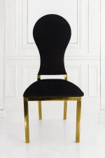 Luxury black velvet dining chair with polished gold stainless steel frame for modern dining rooms.