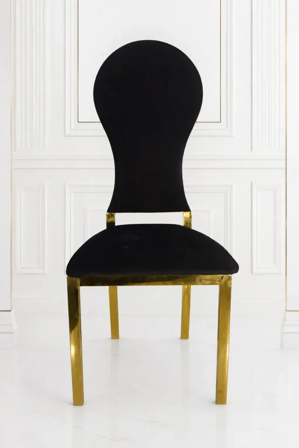 Luxury black velvet dining chair with polished gold stainless steel frame for modern dining rooms.