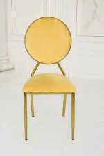 Modern gold stainless steel dining chair featuring a circular velvet backrest and elegant cream seat.