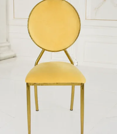 Modern gold stainless steel dining chair featuring a circular velvet backrest and elegant cream seat.