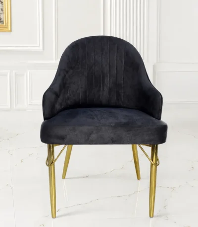 Luxury black velvet accent chair with gold metal legs and curved armrests for modern dining rooms.