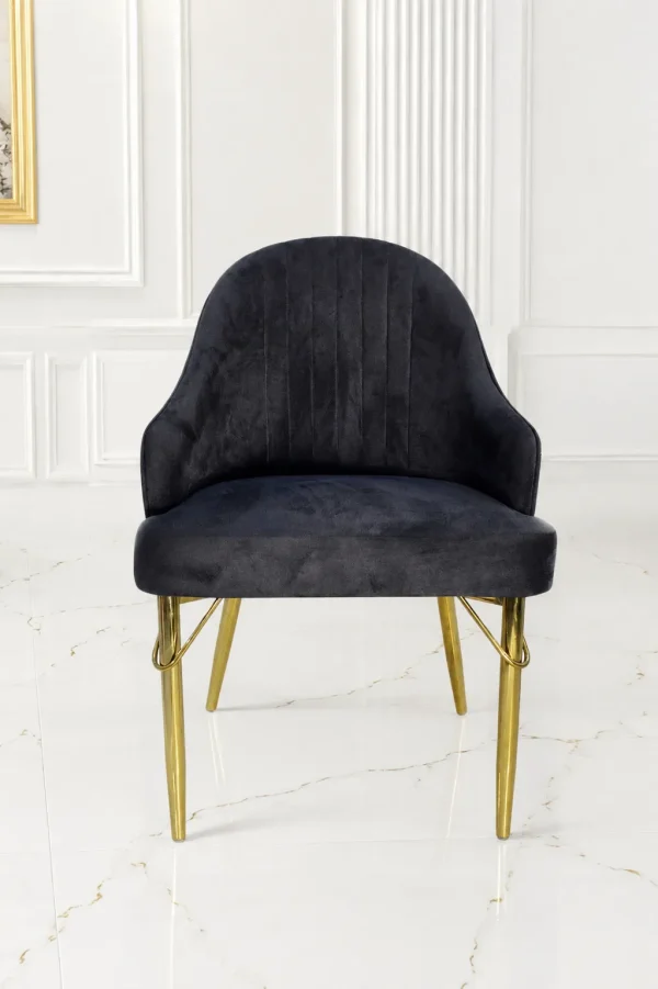 Luxury black velvet accent chair with gold metal legs and curved armrests for modern dining rooms.