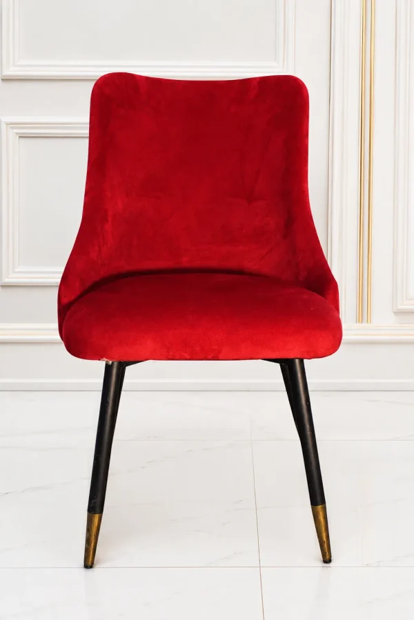Modern red velvet accent dining chair with black metal legs and gold tips.