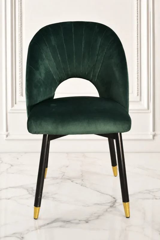 Emerald green velvet dining chair with black metal legs and gold tips