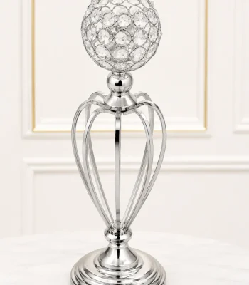 Elegant silver crystal goblet candle holder featuring an open hollow-cage metallic stem and a tiered circular base on a marble table surface.