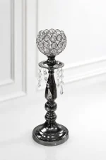 Glamorous gunmetal black crystal candle holder featuring a beaded crystal goblet, hanging crystal teardrop prisms, and a dark metallic tiered pedestal base on a glossy white surfac