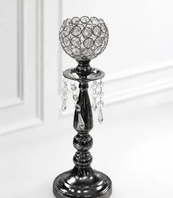 Glamorous gunmetal black crystal candle holder featuring a beaded crystal goblet, hanging crystal teardrop prisms, and a dark metallic tiered pedestal base on a glossy white surfac