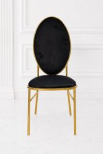 Luxury black velvet dining chair with gold metal frame and oval backrest.